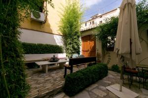 eine Terrasse mit einer Bank und einem Sonnenschirm in der Unterkunft Charming Andalusian House in Granada