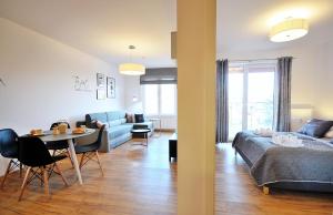a living room with a bed and a dining room at Jantar Apartamenty - Holiday Polanki Park SPA in Kołobrzeg