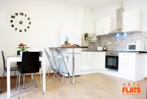 a kitchen with a table and a clock on the wall at Calle Cuenca in Valencia +21 photos