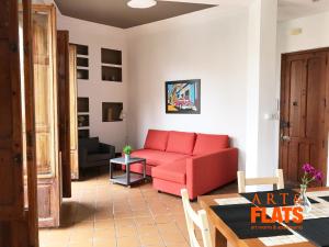 ein Wohnzimmer mit einem roten Sofa und einem Tisch in der Unterkunft CALLE CUENCA 2 in Valencia