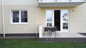 a table and chairs on the porch of a house at Levilena apartament Osiedle Bałtyk in Grzybowo