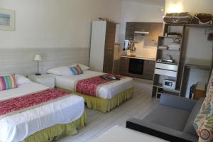 une chambre d'hôtel avec deux lits et une cuisine dans l'établissement Hotel Cayrons Vence & St Paul de Vence, à Vence