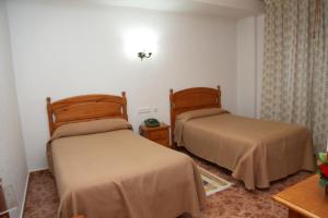 a hotel room with two beds and two lamps at Hotel Los Arcos in El Alquián