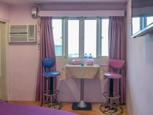 a table and three chairs in a room with a window at Jiufen Ligin B&B in Jiufen