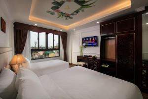 a bedroom with a white bed and a window at Golden Legend Palace Hotel in Hanoi