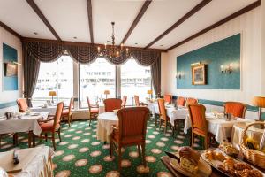 ein Restaurant mit Tischen und Stühlen und einem großen Fenster in der Unterkunft Malecot Hotel by F-Hotels in Blankenberge