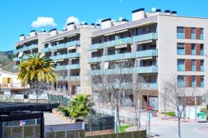 un grand immeuble avec un palmier en face dans l'établissement Villa Bleuor, à Arenys de Mar