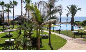 a view of a resort with a pool and palm trees at CN-340 Suites in Estepona