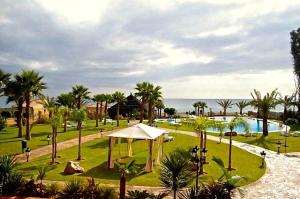 um resort com um parque com piscina e palmeiras em CN-340 Suites em Estepona