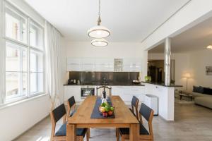 a kitchen and dining room with a wooden table and chairs at Stylish, Light-Filled Home in the Historic Center in Prague