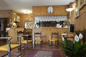 ein Restaurant mit Stühlen und einer Uhr an der Wand in der Unterkunft Albergo Stelvio in Bormio