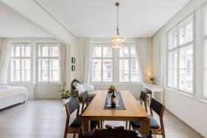 a living room with a wooden table and chairs at Stylish, Light-Filled Home in the Historic Center in Prague