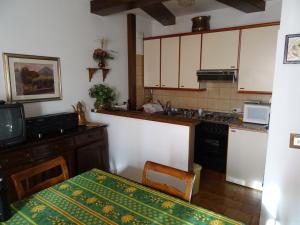 eine Küche mit einem Tisch und einem TV in der Unterkunft I Faggi Rossi in Fanano