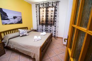 a bedroom with a bed with flip flops on it at Residence Villa Santa Lucia in Cefalù