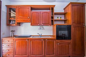 een keuken met houten kasten en een wastafel bij Residence Villa Santa Lucia in Cefalù