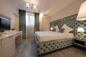 a bedroom with a large bed with a large headboard at Hotel Casa Fiori in Bucharest