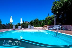 a large swimming pool with chairs at Residence Villa Santa Lucia in Cefalù