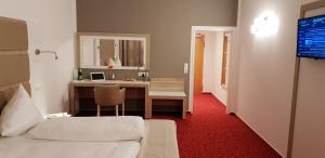 ein Zimmer mit einem Bett und einem Schreibtisch mit einem Computer in der Unterkunft Confour Hotel in Burgdorf