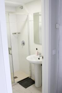 y baño blanco con lavabo y ducha. en Apartamentos Logroño Centro, en Logroño