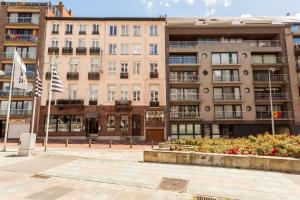 ein Wohnhaus mit Flaggen davor in der Unterkunft Malecot Hotel by F-Hotels in Blankenberge