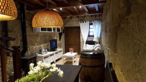 a living room with a barrel and a tv and a room with a table at Casa Do Pazo in Combarro