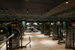 een fitnessruimte met rijen loopbanden en machines bij Nimb Hotel in Kopenhagen