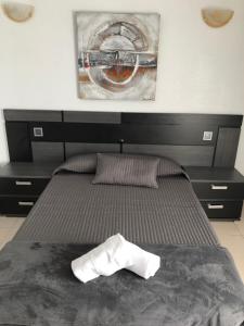 Una cama con un par de toallas blancas. en Hotel Costa Mar, en Loredo