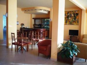 a restaurant with a bar with chairs and a table at Hotel Florida Tirrenia in Tirrenia