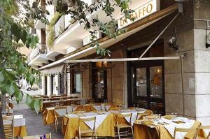 a restaurant with yellow tables and chairs in front of a building at Mammo's House in Rome