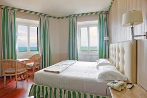 a bedroom with a large bed and a large window at Lolli Palace Hotel in Sanremo