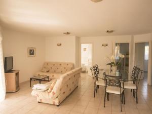 a living room with a couch and a table and chairs at Holiday home with pool in Moriani Plage in San-Nicolao