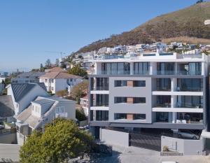 a white apartment building with a hill in the background at The Solis in Cape Town