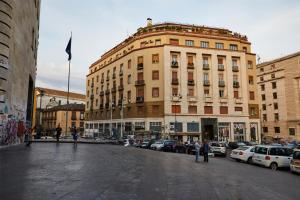 un grand bâtiment avec des voitures garées dans un parking dans l'établissement Luxury Experience | WelcHome Napoli, à Naples
