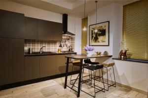 拿坡里的住宿－Luxury Experience | WelcHome Napoli，厨房配有桌子和凳子