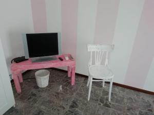 uma secretária rosa com um computador portátil e uma cadeira em Good Morning Shopping em Serravalle Scrivia