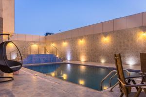 a swimming pool with lights on the side of a building at Al Muhaidb Al Takhasosi Suites in Riyadh