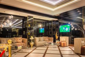 sala de estar con sofás y TV en la pared en Al Muhaidb Al Takhasosi Suites, en Riad
