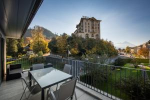 a balcony with a table and chairs and a building at Dependance Penthouse in Interlaken