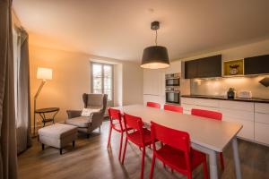 Dependance Penthouse في إنترلاكن: مطبخ وغرفة طعام مع طاولة وكراسي حمراء