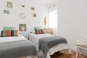 グラナダにあるGenteel Home Santo Cristoの白い壁の客室内のベッド2台