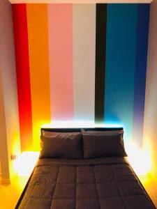 Pokój z łóżkiem z kolorową ścianą w obiekcie Smart House Bologna Centro w Bolonii