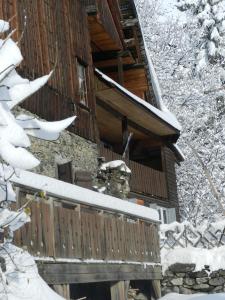 ein Blockhaus im Schnee mit einem Zaun in der Unterkunft L'Epicéa in Saint-Jean-dʼArves