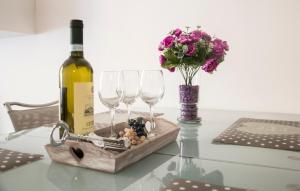 uma garrafa de vinho e dois copos de vinho numa mesa em Leoncino Apartment em Verona