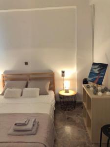 um quarto com uma cama e uma mesa com um candeeiro em Cozy City Apt em Heraclião