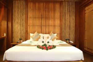 a large white bed with a flower arrangement on it at Railay Village Resort in Railay Beach