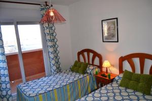 - une chambre avec 2 lits jumeaux et une lampe dans l'établissement Apartamentos Turísticos Hawaii 6, à La Manga del Mar Meno 62 autres photos