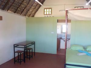 - une chambre avec un lit, une table et des chaises dans l'établissement SANJEELA-PLAGE COCO, à Diego Suarez