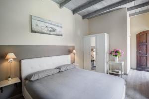 a bedroom with a white bed and a mirror at B&B Magnolia in Cannobio