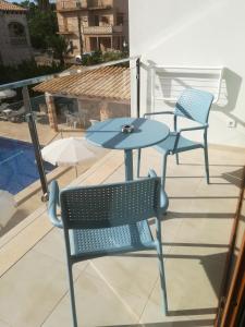 two chairs and a table on a balcony at Apartamentos Villa Primera in Cala Figuera