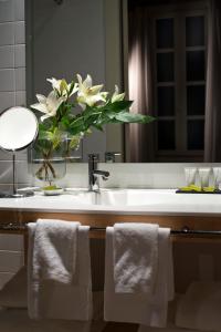 a bathroom with a sink with a vase of flowers at Mercer House Bòria BCN in Barcelona